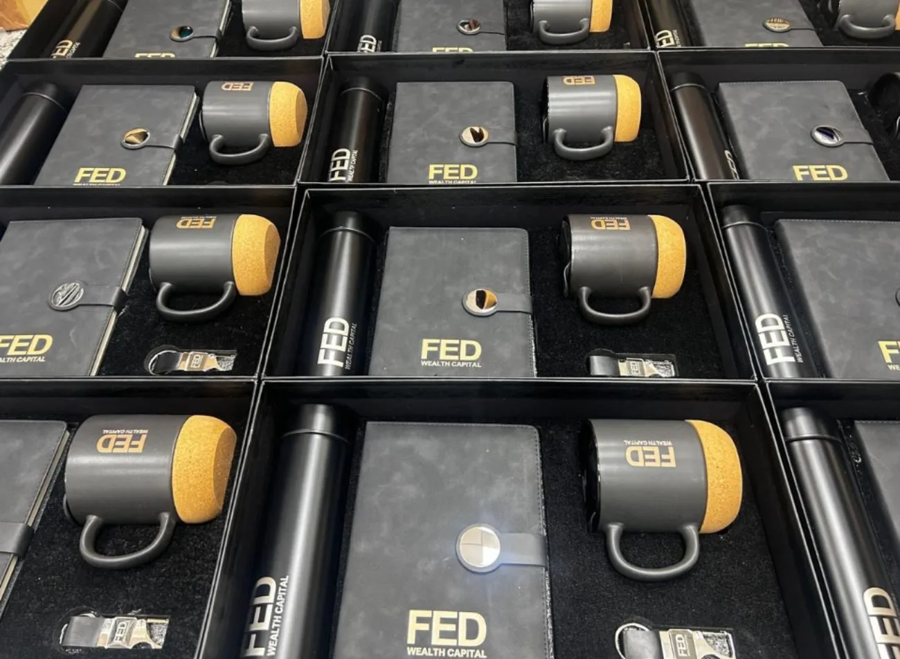 Branded FED Wealth Capital gift kits — diary, cork mug, pen and keychain — packed at scale